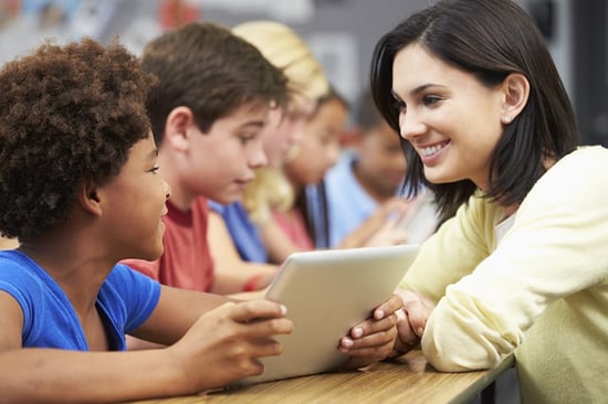 Pupils In Class Using Digital Tablet With Teacher